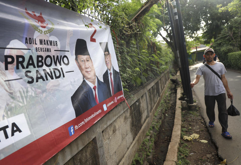 A man walks past a campaign banner for Indonesian presidential candidate Prabowo Subianto, left, and his running mate Sandiaga Uno in Jakarta, Indonesia, Thursday, Jan. 17, 2019. Echoing the campaign tactics of Donald Trump, former Indonesian Gen. Subianto says his country, the world's third-largest democracy, is in dire shape and he is the leader who will restore it to greatness. (AP Photo/Dita Alangkara)