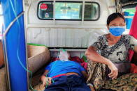 Relative sits with a coronavirus disease (COVID-19) patient being transported to hospital in the town of Kale, Sagaing Region, Myanmar