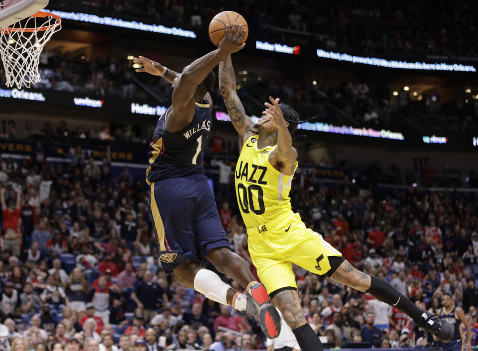 New Orleans Pelicans forward Zion Williamson (1) has his shot blocked by Utah Jazz guard Jordan Clarkson (00) during the second half of an NBA basketball game Sunday, Oct. 23, 2022, in New Orleans. Williamson hit the floor hard on the play and left the game. (Scott Threlkeld/The Times-Picayune/The New Orleans Advocate via AP)