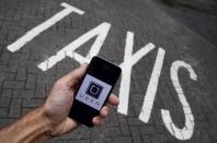 A photo illustration shows the Uber app logo displayed on a mobile telephone, as it is held up for a posed photograph in central London, Britain October 28, 2016. REUTERS/Toby Melville/Illustration