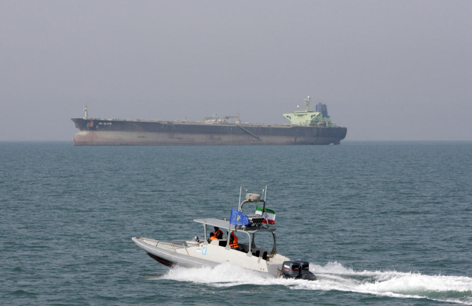 FILE-- In this July 2, 2012 file photo, an Iranian Revolutionary Guard speedboat moves in the Persian Gulf while an oil tanker is seen in background. As nuclear deal threatened, Iran’s politics increasingly under pressure 40 years after Islamic Revolution. In response, President Hassan Rouhan has slowly replaced his message of rapprochement with the West with hard-line hints about Iran’s ability to close off the Strait of Hormuz, through which a third of all oil traded by sea passes. (AP Photo/Vahid Salemi, File)