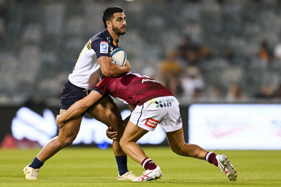 Tom Wright of the Brumbies, left, is tackled by Josh Flook of the Reds during their Super Rugby Pacific match in Canberra, Australia, Saturday, March 11, 2023. (Lukas Coch/AAP Image via AP)