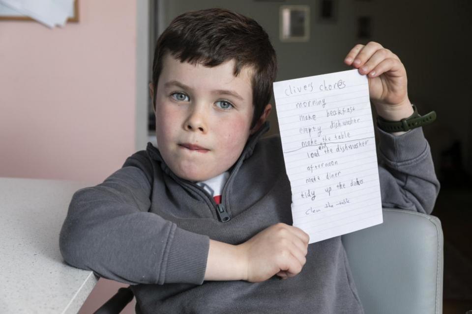 York Press: Clive, six, pictured with his chore list at home in York. Picture: SWNS