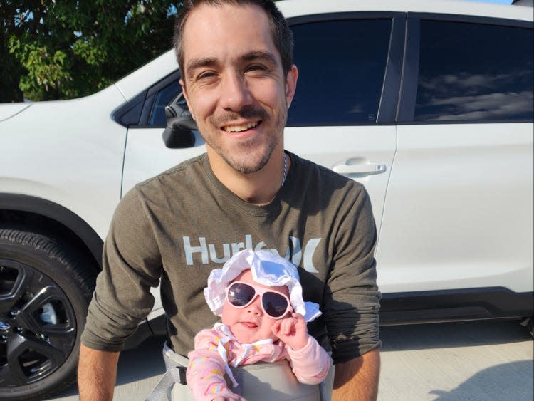 Zac Wolfe in his wheelchair with his baby daughter, Charlie.