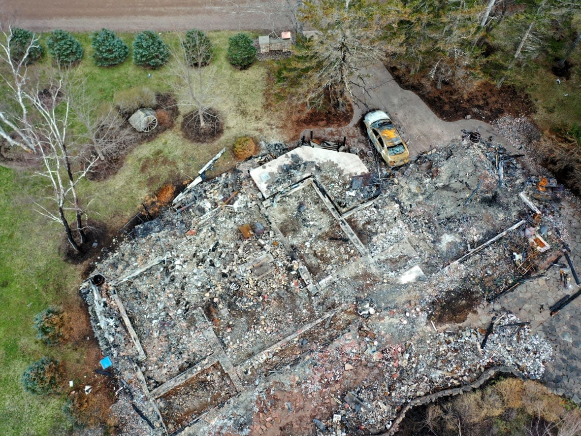 The burned remains of Gabriel Wortman’s cottage, seen here with the unmarked Ford Taurus Police Interceptor sedan parked outside. Wortman disguised himself as a Mountie and over the course of 13 hours the night of April 18, 2020, and the following morning travelled nearly 200 kilometres in and around Portapique, Nova Scotia, killing 22 people.  (Steve Lawrence/CBC - image credit)