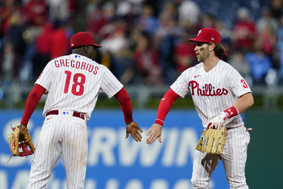 Philadelphia Phillies' Didi Gregorius, left, and Bryce Harper celebrate after a baseball game against the Pittsburgh Pirates, Friday, Sept. 24, 2021, in Philadelphia. (AP Photo/Matt Slocum)