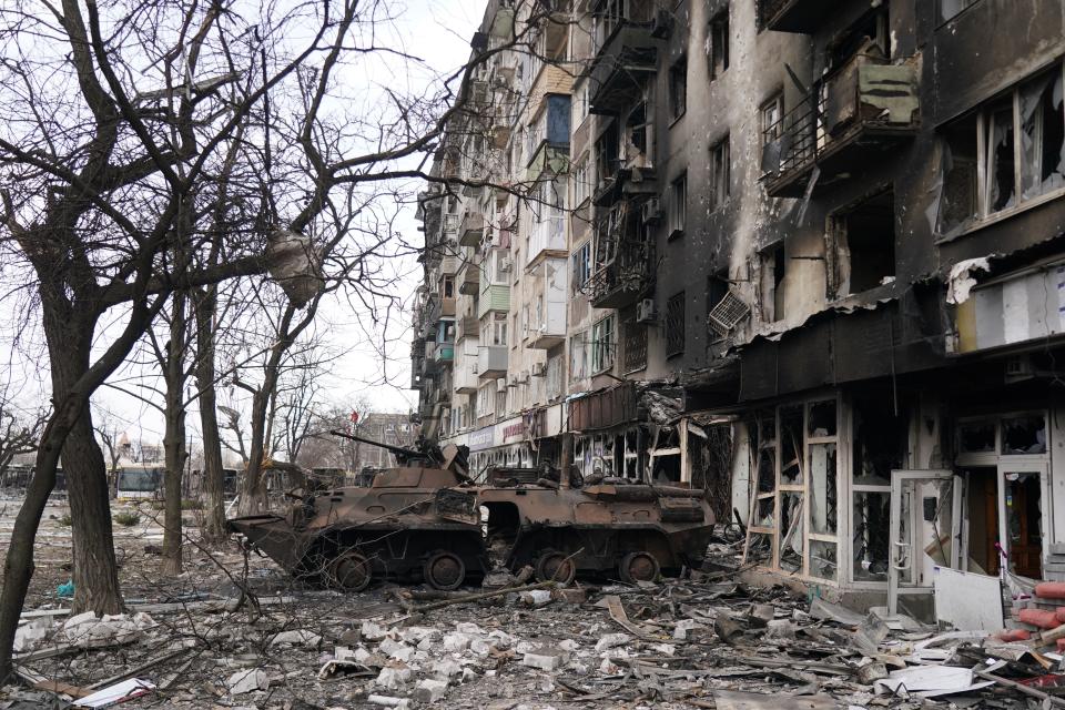 A wrecked tank is seen near a damaged building in Mariupol, Ukraine