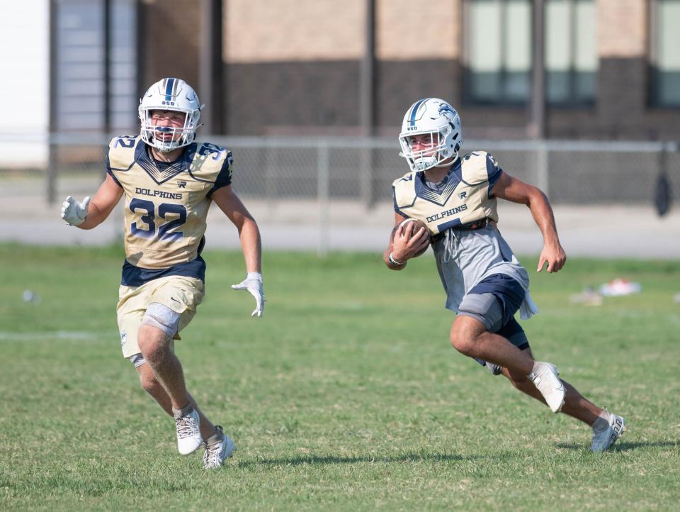 Bryson Rouillier (7) carries the ball during football practice at Gulf Breeze High School on Thursday, Aug. 3, 2023.