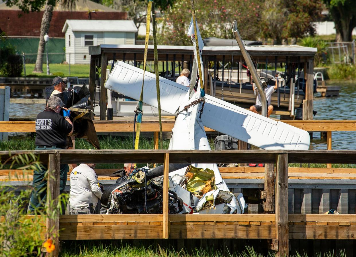 Investigators photograph a Piper PA-28 Cherokee as it is removed from Lake Hartridge after a fatal collision on March 9.