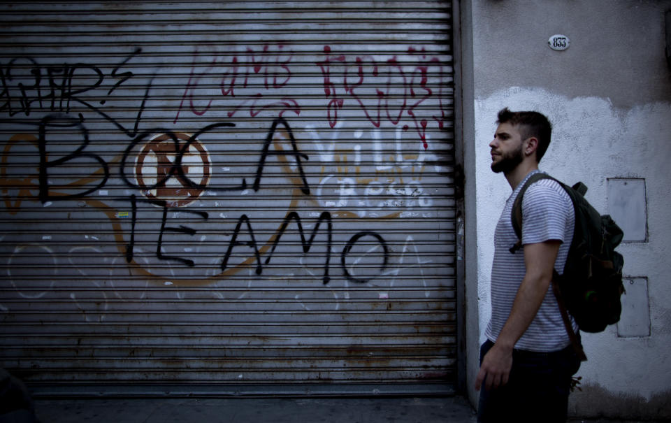 A man walks by a graffiti reading " Boca Juniors I love you" in Buenos Aires, Argentina Wednesday, Nov. 7, 2018. Boca Juniors will face Play River Plate for the Copa Libertadores final match. (AP Photo/Natacha Pisarenko)