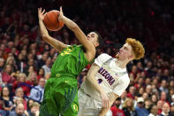 Oregon guard Anthony Mathis (32) is fouled by Arizona guard Nico Mannion during the first half of an NCAA college basketball game Saturday, Feb. 22, 2020, in Tucson, Ariz. (AP Photo/Rick Scuteri)