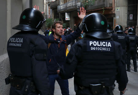 A demonstrator raises his hands in front of the police during a protest against Spain's cabinet meeting in Barcelona, Spain, December 21, 2018. REUTERS/Sergio Perez