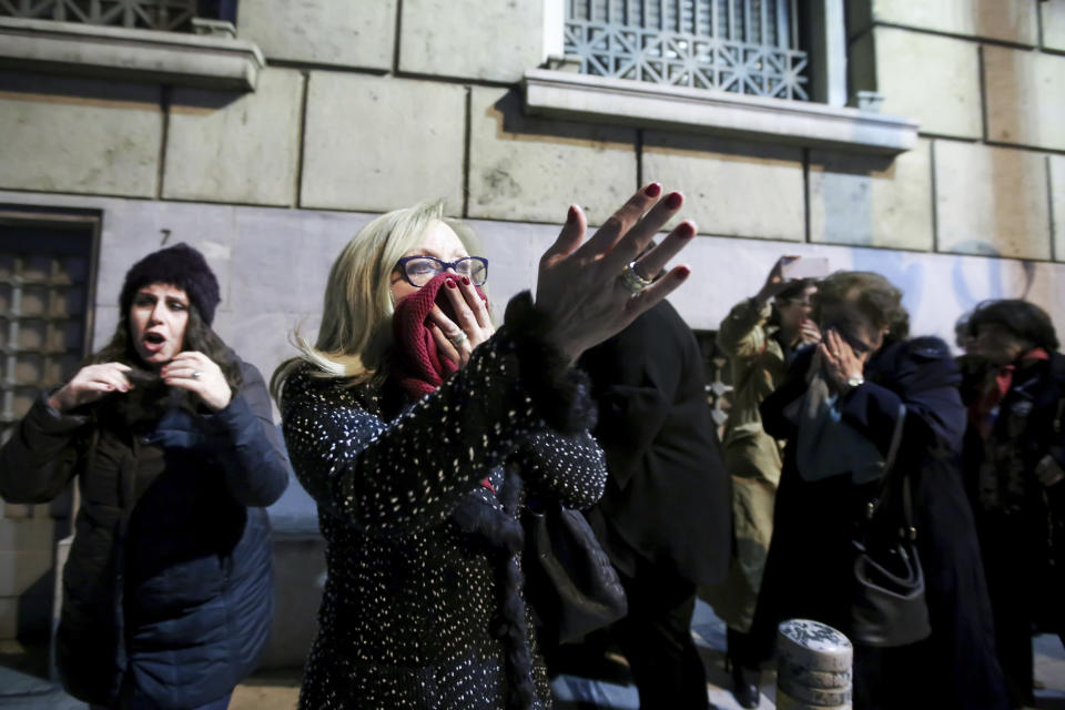 People cover their face to protect their selfs from the tear gas throwing from riots police during clashes with protestors against the visit of German Chancellor Angela Merkel in Athens, Thursday Jan. 10, 2019. Greek riot police used tear gas against a small group of left-wing activists protesting the visit of German Chancellor Angela Merkel to Athens. (InTime News via AP)