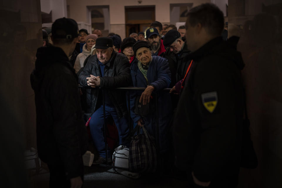 Ukrainians queue to board the Kherson-Kyiv train at the Kherson railway station, southern Ukraine, Monday, Nov. 21, 2022. Ukrainian authorities are evacuating civilians from recently liberated sections of the Kherson and Mykolaiv regions, fearing that a lack of heat, power and water due to Russian shelling will make conditions too unlivable this winter. The move came as rolling blackouts on Monday plagued most of the country. (AP Photo/Bernat Armangue)