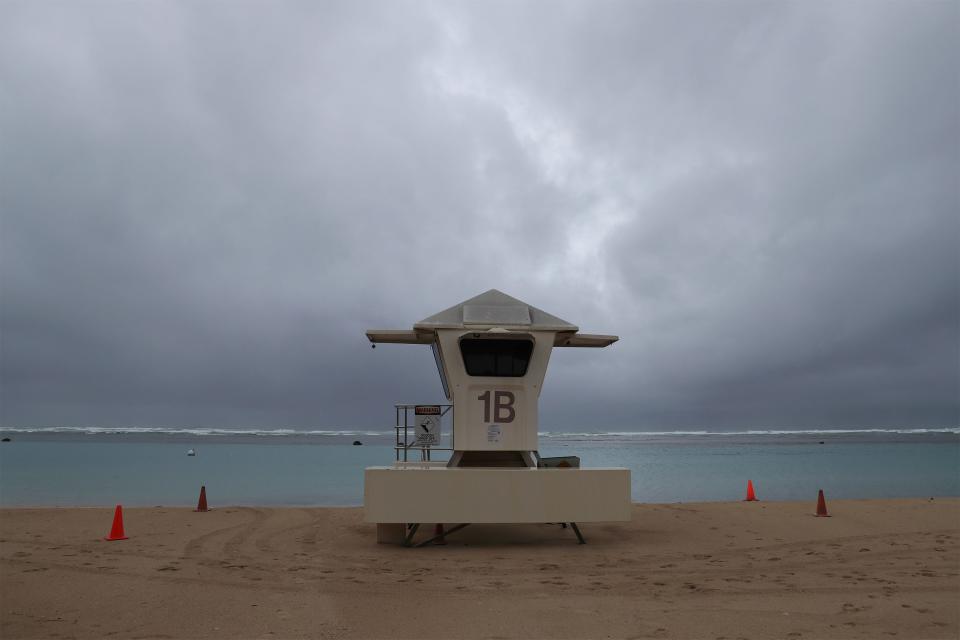 Dark clouds hang over a lifeguard tower on Ala Moana Beach Park, Monday, Dec. 6, 2021, in Honolulu. (AP Photo/Marco Garcia) ORG XMIT: HIMG102