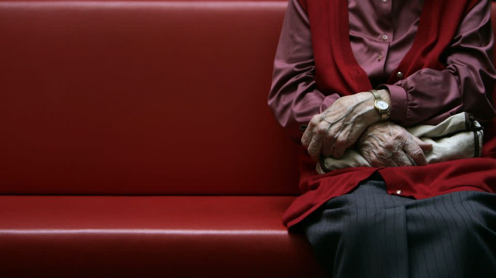 An image of a person sitting at the end of a Church pew