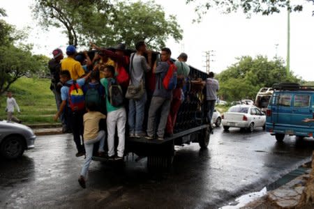 Commuters ride on a cargo truck used as public transportation in Valencia, Venezuela July 11, 2018. Picture taken July 11, 2018. REUTERS/Marco Bello