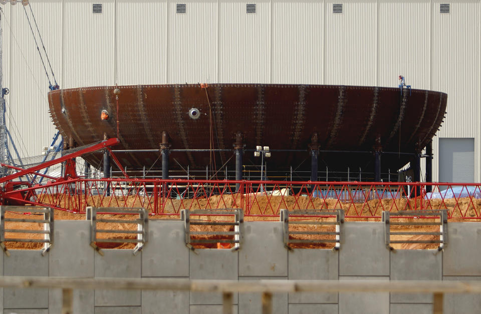 FILE- In this Feb. 15, 2012 file photo, the new reactor vessel bottom head for unit 3 stands under construction at the Vogtle nuclear power plant in Waynesboro, Ga. Vogtle initially estimated to cost $14 billion, has run into over $800 million in extra charges related to licensing delays. A state monitor has said bluntly that co-owner, Southern Co. can’t stick to its budget. The plant, whose first reactor was supposed to be operational by April 2016, is now delayed seven months. (AP Photo/David Goldman, File)