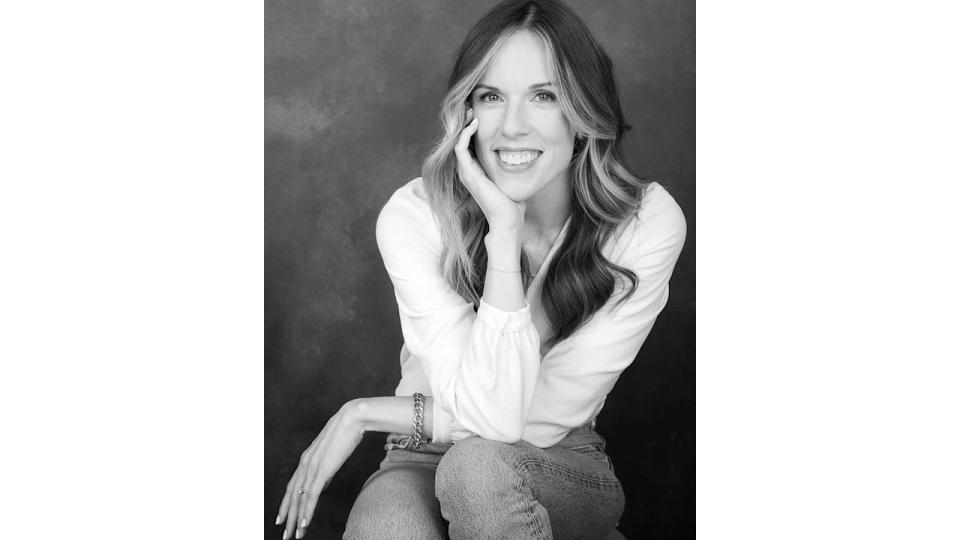 Woman smiling in black and white, wearing a white shirt 