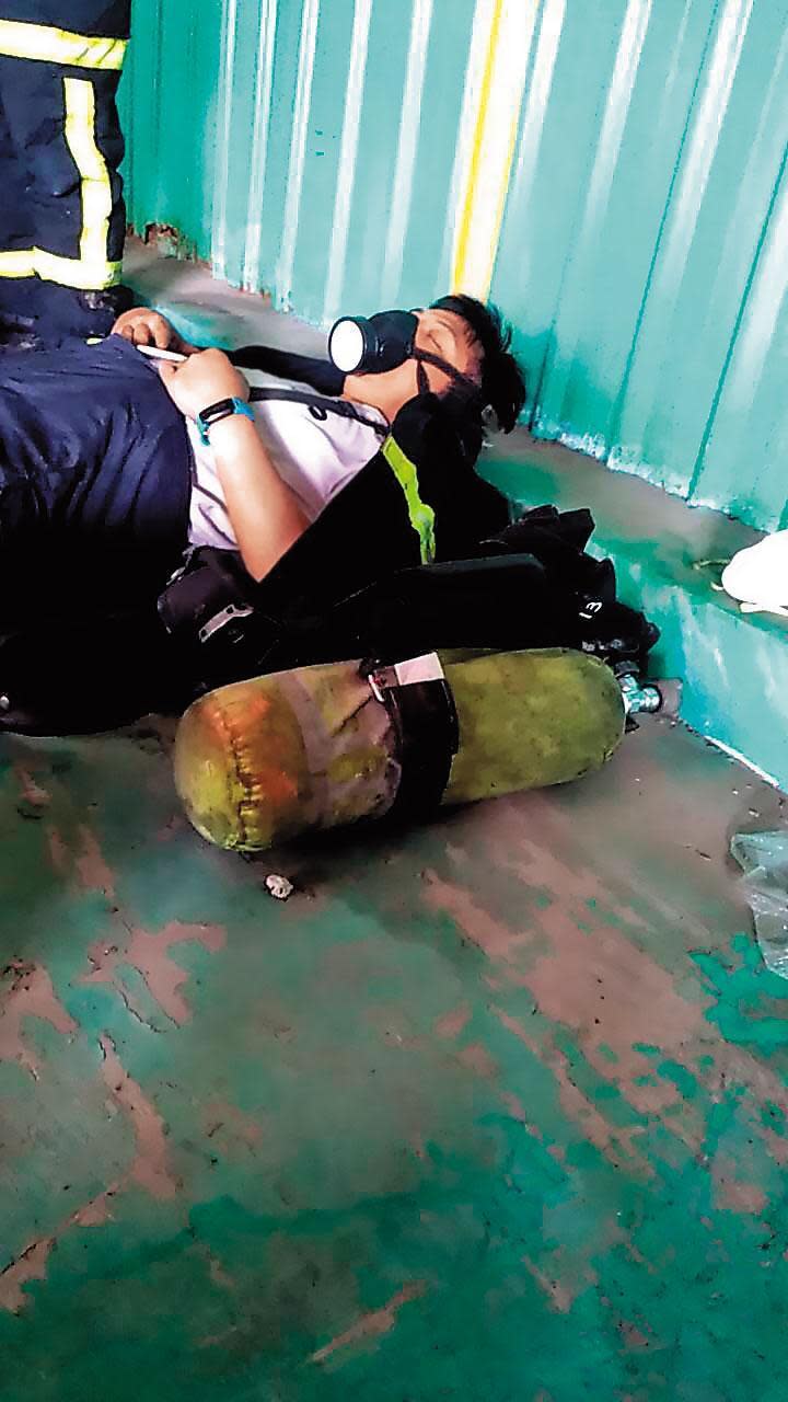 敬鵬公司大火延燒多時，現場消防人員因搶救而精疲力盡，裝備來不及卸下就席地而躺。