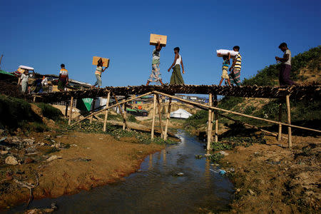 Rohingya refugees carry supplies at Kutupalong refugee camp, near Cox's Bazar, Bangladesh, November 20, 2017. REUTERS/Susana Vera