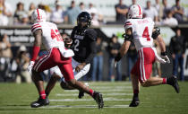 Colorado quarterback Shedeur Sanders, center, is pursued by Nebraska linebackers Mikah Gbayor, left, and Luke Reimer in the first half of an NCAA college football game Saturday, Sept. 9, 2023, in Boulder, Colo. (AP Photo/David Zalubowski)