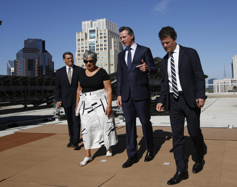 FILE - In this Aug. 13, 2019, file photo, California Gov. Gavin Newsom, second from right, tours the solar panels atop the building housing the California Environmental Protection Agency, accompanied by Attorney General Xavier Becerra, left, California Air Resources Board Chair Mary Nichols, and California EPA Director Jared Blumenfeld, right, in Sacramento, Calif. Nichols' term leading the state ARB ends in December 2020. She's held the role since 2007 after an earlier stint as chair in the early 1980s. (AP Photo/Rich Pedroncelli, File)