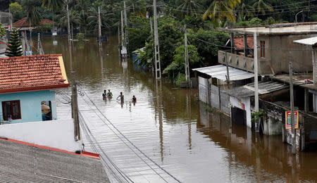 A group of men walk through a flooded road during a rescue mission in Nagoda village in Kalutara, Sri Lanka May 29, 2017. REUTERS/Dinuka Liyanawatte