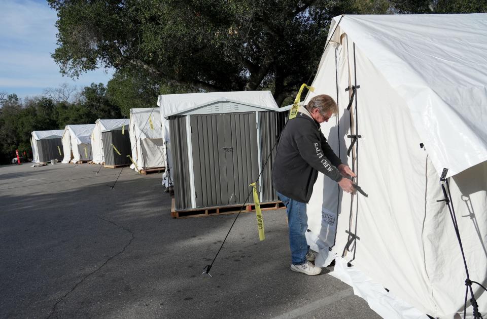 Rick Raine, homeless services coordinator for the city of Ojai, looks at new tents in the parking lot of Kent Hall on Wednesday.
