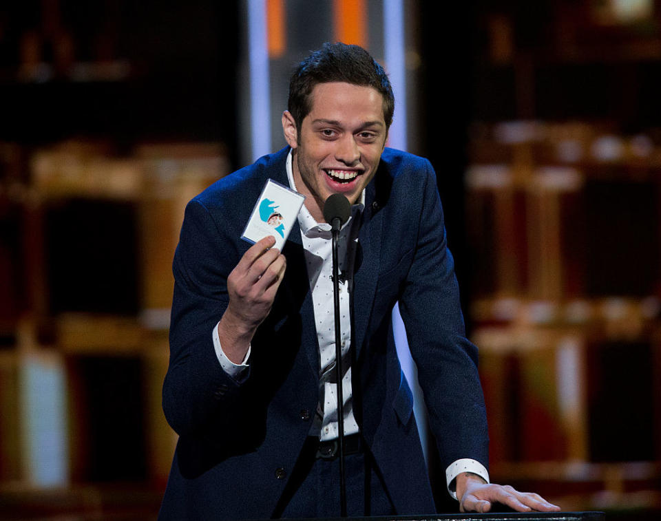 Pete holding up a card while talking into a mic