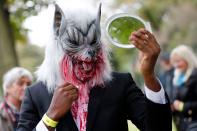 <p>A participant checks their costume before taking part in a in a zombie walk on World Zombie Day in London on Oct. 7, 2017. (Photo: Tolga Akmen/AFP/Getty Images) </p>