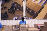This image taken from video shows people working inside the UNICEF warehouse, the world's largest humanitarian aid warehouse, in Copenhagen, Denmark , Tuesday Oct. 13, 2020. For Burkina Faso, India, Venezuela and other countries with shaky health care delivery systems, the best chance for receiving scarce supplies of a coronavirus vaccine is through the Covax initiative, led by the World Health Organization and the Gavi vaccine alliance. UNICEF began laying the groundwork months ago in Copenhagen, at the world's largest humanitarian aid warehouse. (AP Photo)