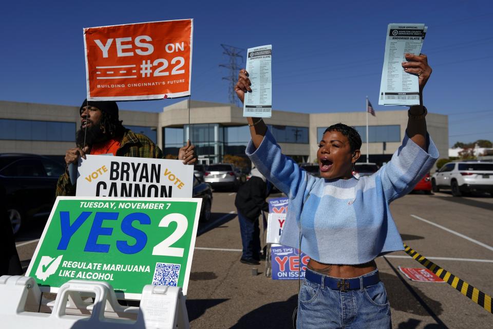 FILE - Nikko Griffin, left, and Tyra Patterson, call out to arriving voters for several issues, including Issue 2, legalizing recreational marijuana, at a parking lot during early in-person voting in Cincinnati, Nov. 2, 2023. A new law banning foreign nationals and green card holders from contributing to state ballot campaigns in Ohio curtails the constitutionally protected rights of free speech and association, according to a lawsuit filed Thursday, June 28, 2024 in federal court.(AP Photo/Carolyn Kaster, File)