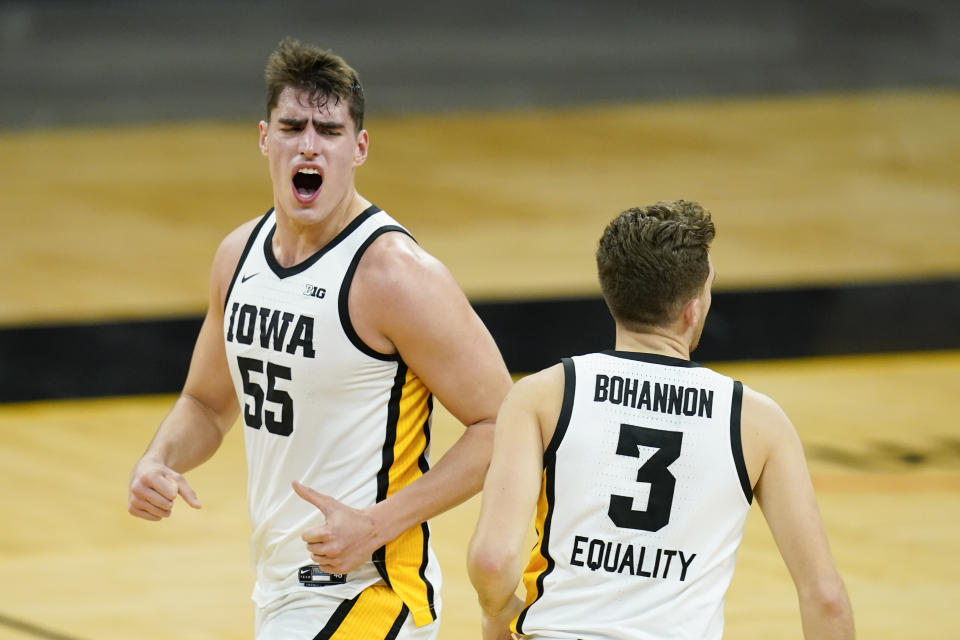 Iowa center Luka Garza (55) celebrates with teammate Jordan Bohannon (3) after making a 3-point basket during the first half of an NCAA college basketball game against Minnesota, Sunday, Jan. 10, 2021, in Iowa City, Iowa. (AP Photo/Charlie Neibergall)
