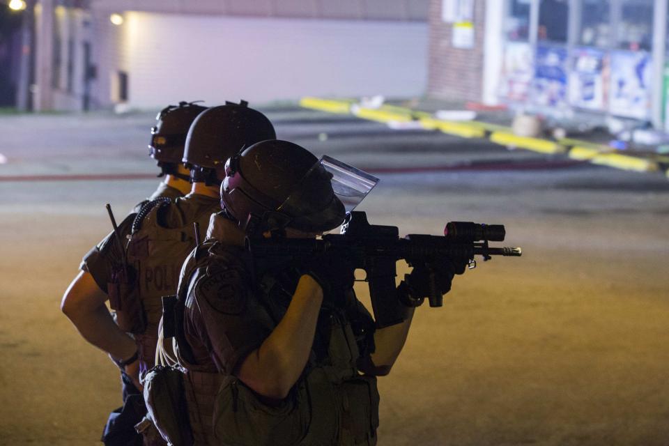 Police officers react at the scene of a looting at the Dellwood Market after protests against the shooting of Michael Brown turned violent near Ferguson, Missouri August 17, 2014. Shots were fired and police shouted through bullhorns for protesters to disperse, witnesses said, as chaos erupted Sunday night in Ferguson, Missouri, which has been racked by protests since the unarmed black teenager was shot by police last week. REUTERS/Lucas Jackson (UNITED STATES - Tags: CIVIL UNREST CRIME LAW)