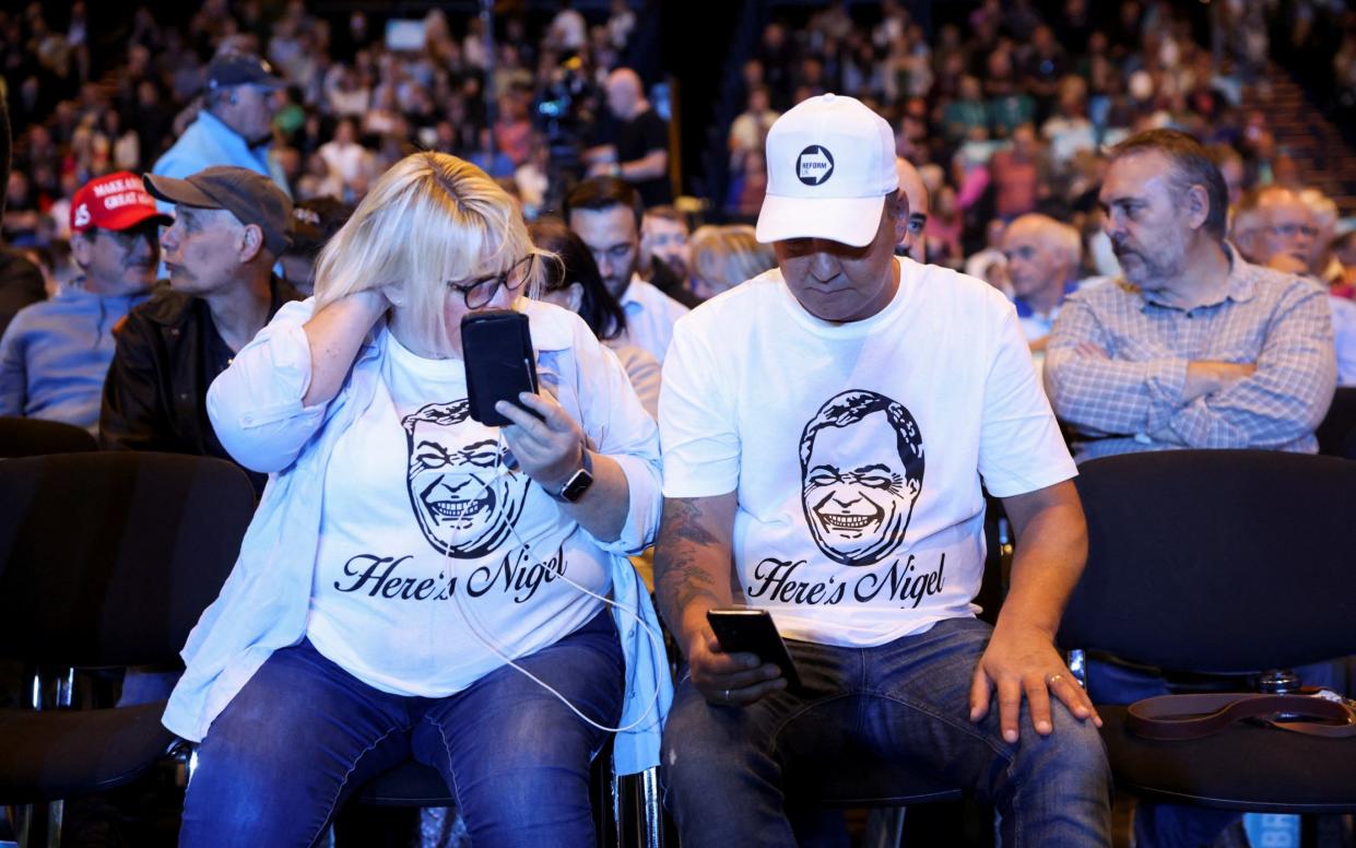 Nigel Farage supporters take seats ahead of Reform UK's rally at the NEC in Birmingham