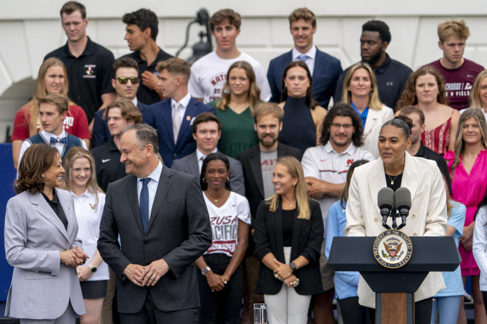 University of Texas at Austin volleyball player Logan Eggleston, right, accompanied by Vice President Kamala Harris, left, and Doug Emhoff, husband of Harris, second from left, speaks as the women's and men's NCAA Champion teams from the 2022-2023 season are celebrated during College Athlete Day on the South Lawn of the White House, Monday, June 12, 2023, in Washington. (AP Photo/Andrew Harnik)