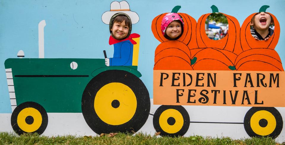 Ethan Bybee, Kylee Gregg and Eric Hammond makes faces as they pose in the cutout during Children's Farm Festival at Peden Farm on Thursday, Sept. 29, 2022.