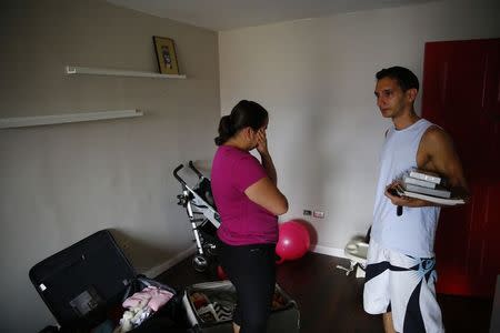 Natalie Pereira (C) cries as she says goodbye to her friend before her move to the U.S. with her family, after winning the Green Card lottery, at their home in Valencia April 6, 2014. REUTERS/Jorge Silva