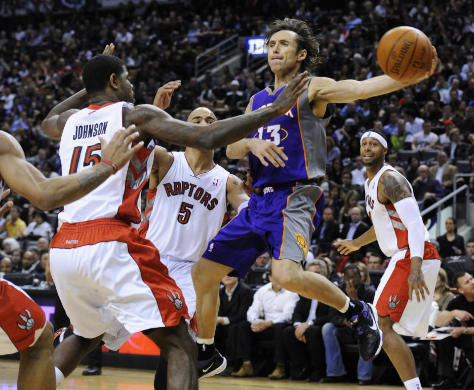 Suns Nash passes the ball off around Raptors Johnson, Bayless, and Johnson during their NBA basketball game in Toronto. 2011. Mark Blinch / Reuters