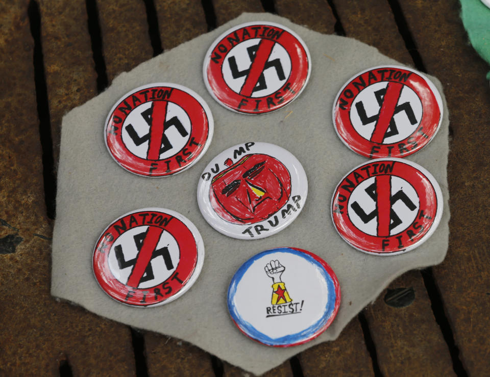 A vendor displays wares on the mall as State Police lock down the downtown area in anticipation of the anniversary of last year's Unite the Right rally in Charlottesville, Va., Saturday, Aug. 11, 2018. The Governor has declared a state of emergency in Charlottesville. (AP Photo/Steve Helber)