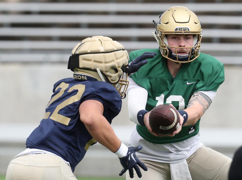 Akron's Charles Kellom takes a handoff from Jeff Undercuffler Jr. during the 2023 spring football game Saturday.