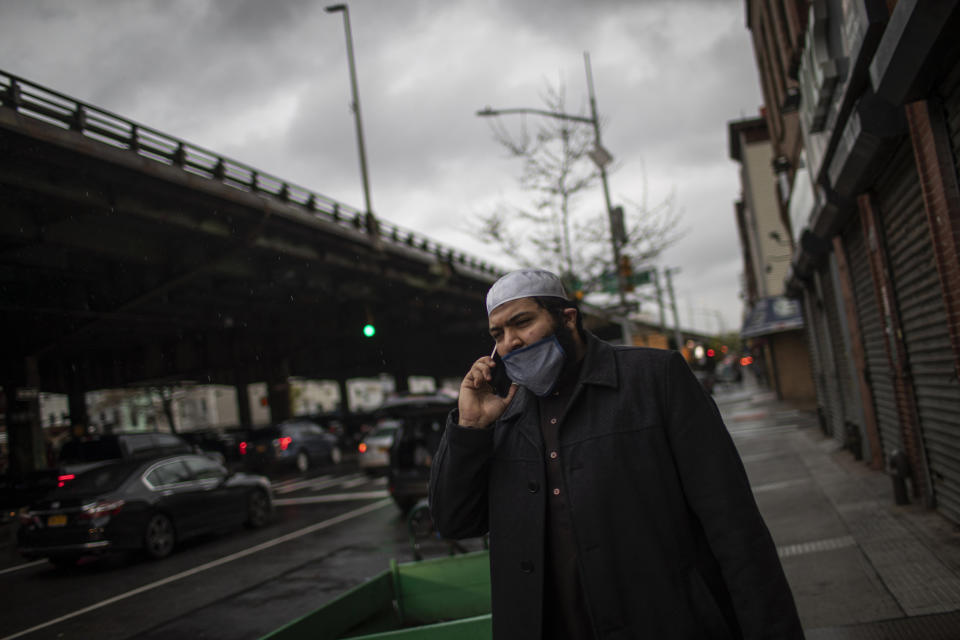 Abdullah Salem, 26, an imam at the Muslim Community Center, in the Bay Ridge, speaks on his phone as he prepares to head out with volunteers of Muslims Giving Back to hand out warm meals to people in need in the Brooklyn borough of New York on Friday, April 24, 2020. (AP Photo/Wong Maye-E)