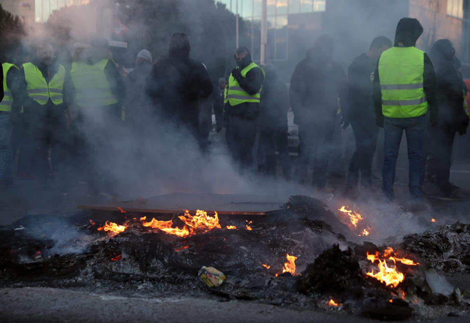 <p>Decenas de taxistas se mantienen junto a una de las hogueras con las que lograron cortar el tráfico en Madrid. (Foto: Sergio Perez / Reuters). </p>