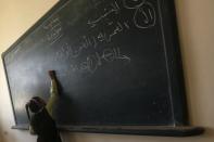 A girl writes on the blackboard on the first day of her new school year at a government school in Giza, south of Cairo September 22, 2013. Students resumed their studies at the beginning of the new academic year this weekend amid parental concerns of a possible lack of security after the summer vacation ends. REUTERS/Mohamed Abd El Ghany (EGYPT - Tags: POLITICS EDUCATION)