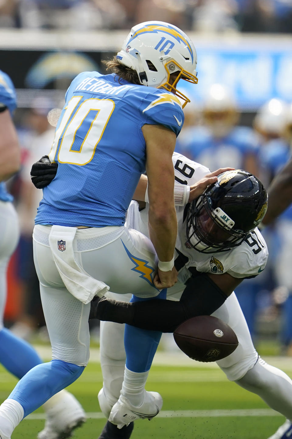 Los Angeles Chargers quarterback Justin Herbert (10) fumbles the ball as he is sacked by Jacksonville Jaguars defensive end Dawuane Smoot (91) during the first half of an NFL football game in Inglewood, Calif., Sunday, Sept. 25, 2022. The Jaguars recovered the ball. (AP Photo/Marcio Jose Sanchez)