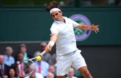 Switzerland's Roger Federer plays a forehand shot during his men's singles quarter-final against Russia's Mikhail Youzhny at Wimbledon on Wednesday. Defending champion Novak Djokovic and six-time winner Roger Federer face a titanic Wimbledon semi-final showdown after the two title contenders wasted little time on their last eight matches on Wednesday