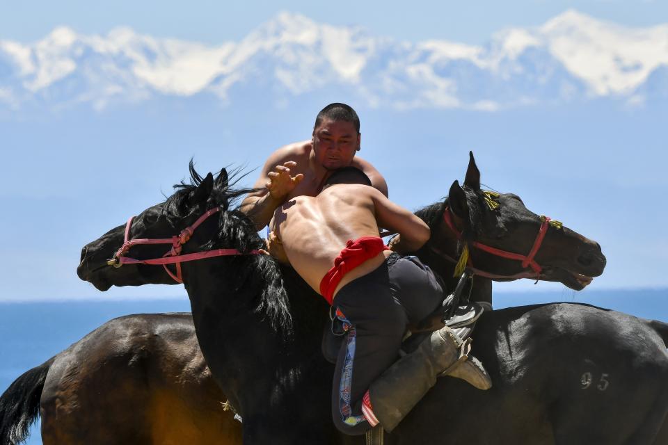 Kyrgyz horse riders compete during a kok boru, also called ulak tartysh, a traditional game in which players on horseback manoeuvre with a goat's carcass and score by putting it into the opponents' goal outside Bosteri village, 202 km, (126 miles) southeast of Bishkek, in the Issyk-Kul Region of Kyrgyzstan, Saturday, June 1, 2024. (AP Photo/Vladimir Voronin)