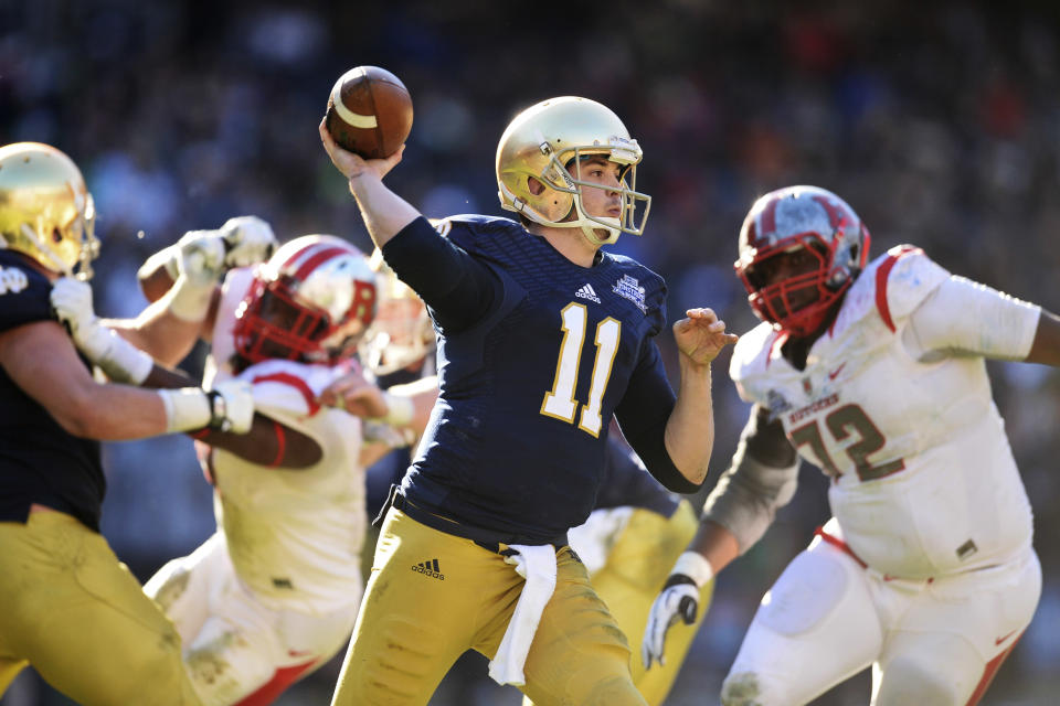 Dec 28, 2013; Bronx, NY, USA; Notre Dame Fighting Irish quarterback Tommy Rees (11) throws a pass against the Rutgers Scarlet Knights during the first half of the Pinstripe Bowl at Yankee Stadium. Joe Camporeale-USA TODAY Sports