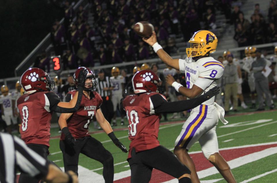 Reynoldsburg's Jarin Mock passes while under pressure from Newark's Kalen Winbush (10), Preston Lunsford (8) and Austin Rose (7) during the visiting Raiders' 35-21 victory Friday.